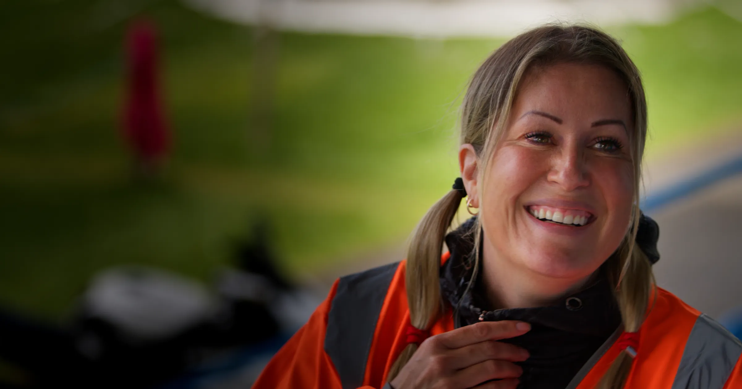 NikiWho? Wearing a TT Marshals orange high-visibility vest, sitting for an interview, filmed by DotPerformance for the Isle of Man TT Marshals video campaign